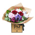 A bouquet of flowers consisting of pink hydrangea, red roses, red hypericum, pink waxflower, and purple spray roses, wrapped in Gold cello with a ribbon, presented in a card box with &