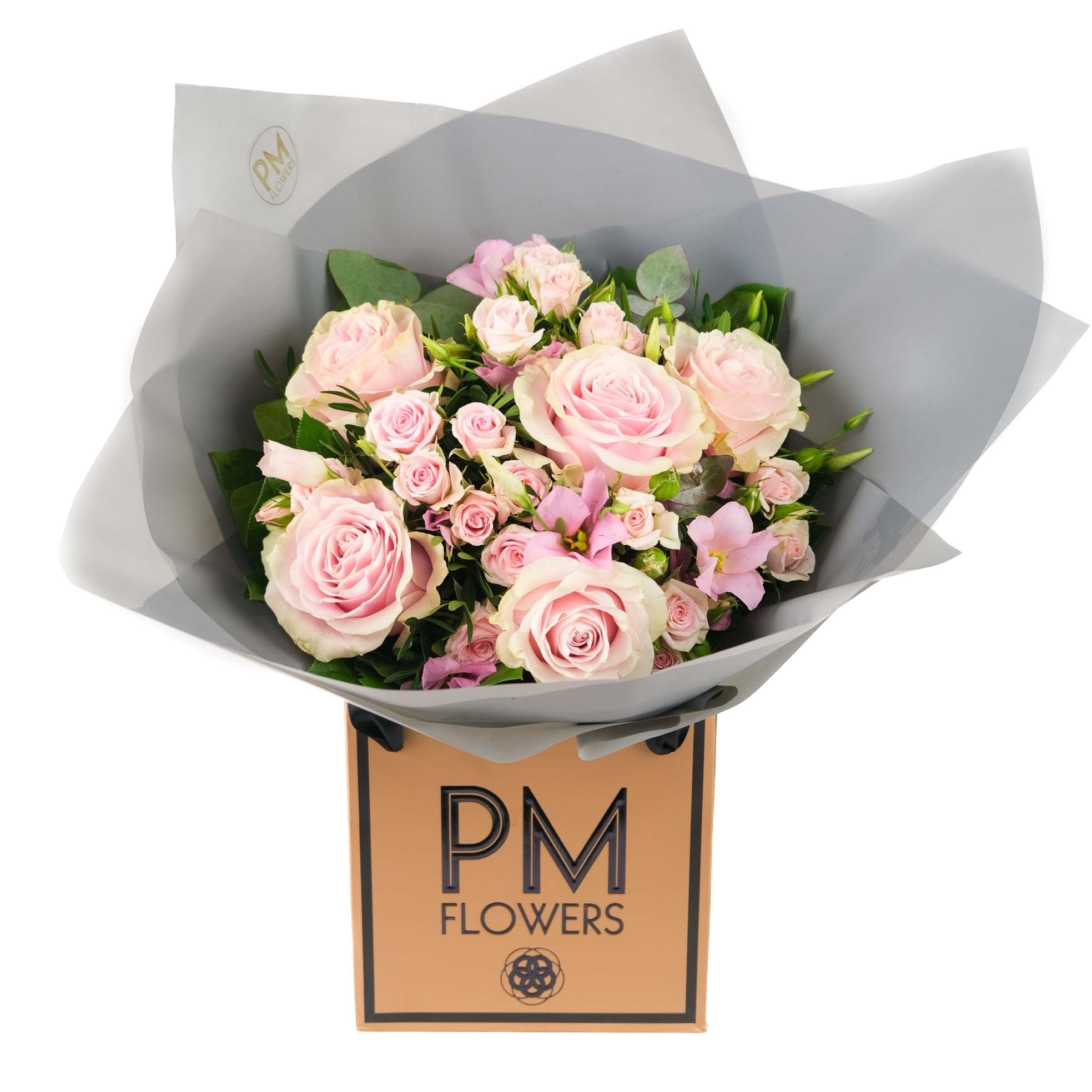 A bouquet of light pink flowers including roses and lisianthus, wrapped in grey paper with &