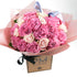 A bouquet of pink roses with cerise fluffy roses and light pink roses, arranged in a box with a ribbon.